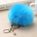 Détail d'un porte-clés pompon bleu ciel avec fermoir doré et pendentif boule en strass - 8cm / Bleu Moyen & Blanc