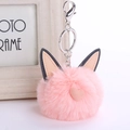 Fluffy pink cat ear keychain with plush faux fur ball and heart charm on white background - Pink