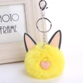 Detailed shot of yellow fluffy cat keychain with pink heart and silver metal lobster clasp - Yellow