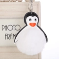 Detalle de un llavero de pingüino de peluche con gran bola de pelo blanca y cuero - 16cm+8cm / Blanco