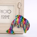 Close-up of a dolphin-shaped keychain with colorful scales made of glittery sequins - 14cm x 8cm / Rainbow