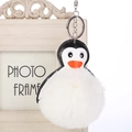 Primer plano del llavero de pingüino con pompón de pelo sintético blanco y metal - 16cm+8cm / Blanco Roto