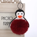 Detalle del llavero de pingüino con pompón de piel sintética burdeos y alas de cuero - 16cm+8cm / Burdeos