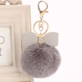 Detail of dark grey faux fur keychain with rhinestone bow and gold lobster clasp - 8cm / Dark Gray