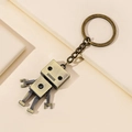 Portachiavi robot vintage in lega di bronzo con arti mobili su sfondo minimalista - Bronzo
