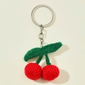 Portachiavi con ciliegie rosse fatte a mano all'uncinetto con foglie verdi su bianco - Come mostrato
