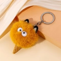 Detail van pluizige oranje monster pluche sleutelhanger met ijsje basis en schattige ogen - Geel