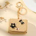 Mini beige quilted leather pouch keychain with black flower and bow on a soft background - Quilted Style Bag Keychain / Khaki