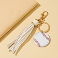 Baseball keychain featuring a white tassel and golden lobster clasp on a beige background - White