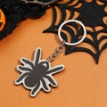 Halloween spinnensleutelhanger met zwarte acryl hanger op een oranje achtergronddecor - Spin