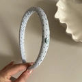 Detail of light blue polka dot headband with handmade label and twill fabric texture - Blue