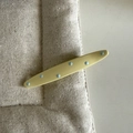 Chic cream hair clip with blue polka dots on a neutral textured fabric background - Oval Blue Polka Dot Style / Yellow