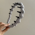 Minimalist grey twisted cloth headband with non-slip plastic teeth shown on plain background - Gray Marble Texture