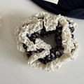 Makro-Detail des Retro-Blumen-Haargummis mit doppellagiger cremefarbener Spitze - Schwarz Weißer Rand