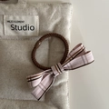 Dettaglio ravvicinato di un elastico per capelli con fiocco a quadri rosa su lino - Elastico Capelli Fiocco Righe Rosa