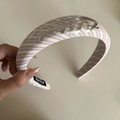 Nahaufnahme eines breiten rosa gestreiften Stirnbandes mit silbernem Logo und Polsterdesign - Rosa Gestreiftes Buchstaben-Stirnband
