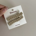 Primer plano de pinzas para el cabello marrones con costuras amarillas en cartón - Estilo Ondulado Café