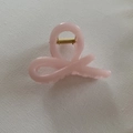 Detail view of pink jelly hair claw clip with golden spring on white textured fabric - Light Pink Twist (14#)