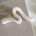 Detailed macro view of the wavy cream white marble acetate hair claw clip with golden spring - White Wavy Claw