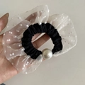 Dettaglio di un elastico per capelli in rete a pois bianchi e neri con una grande perla - Anello per Capelli Nero in Pizzo a Pois Bianchi Perla