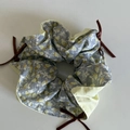 Dettaglio dell'elastico per capelli floreale grigio-blu con fiori gialli e fiocco rosso - Elastico Floreale Blu con Tre Fiocchi
