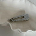 Détail de la pince à cheveux argentée avec strass et nœud sur un plateau - Nœud Pince à Bec de Canard Triangle / Argenté