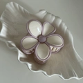 Macro d'une pince à cheveux fleur crème aux bords violets sur un plateau coquillage - Pétale Blanc Crème Bord Violet
