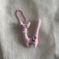 Detailed close-up of a pink fabric cat pendant with pearl necklace and embroidery - Pink Cat With Pink Lanyard