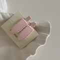 Close-up of two pink matte hair clips with stitch details on elegant display shell - Pink