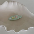 Detalle de pinza para pelo verde menta con estrellas rosas y lazo amarillo en bandeja - Accesorios Estrella Lazo / Verde