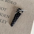 Detail of black polka dot hair clip featuring a silver bow and heart charm on linen - Black White Polka Dot Long Triangle