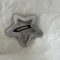 Detailed top view of silver star hair clip with embossed texture and black snap closure - Silver Star Style
