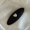 Barrette ovale noire élégante avec texture pailletée et motif cœur argenté central - Noir Ovale Cœur Argent / Noir