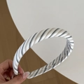 Detalle de la textura de tela a rayas y acabado liso en la diadema ancha de moda - Diadema Rayada Negra Té con Leche