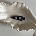 Dettaglio del fermaglio per capelli in tessuto blu scuro con fiori argentati su vassoio - Fermaglio Becco d'Anatra Triangolo Marino Doppi Fiori d'Argento