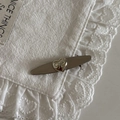 Close-up of heart-shaped bow buckle on a dark beige hair clip with lace background - Silver Long White Striped Bow Heart