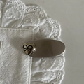 Close-up of vintage heart hair clip with black bow on elegant white lace fabric - Silver Oval Black Striped Bow Heart