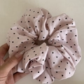 Detailed view of pink cotton scrunchie with black heart pattern held by hand - Pink Scrunchie (Heart)