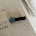 Detail of blue matte flower hair clip with yellow rhinestone on beige texture - Blue Flower Duckbill Clip