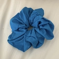 Detailed view of dark blue fabric scrunchie texture with elastic inner band for hair - Blue
