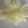 Detailopname van lichtgele chiffon haarelastiek met witte stippen en zachte textuur - Geel