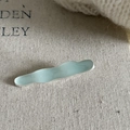 Minimalist mint green wave metal hair clip with gold finish on textured beige linen cloth - Blue Wave Duckbill Clip