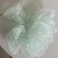 Detailopname van lichtgroene organza scrunchie met stippen en een zachte textuur - Groen