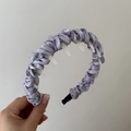 Detailed macro view of lavender pleated satin headband with wavy texture and white inner teeth - Purple Wrapped Headband With Teeth