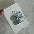 Silver metal oval hair clips set with light blue ribbon bows on cream display card - Silver Oval Hair Clip Blue Bow Style