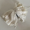Dettaglio di un pettine per capelli in pizzo beige retrò con fiocco e denti neri - Bianco Sporco