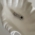 Detaillierte Makroansicht der silbernen Blumen-Haarklammer mit schwarzer Perle auf Schale - Entenschnabel-Haarclips / Silberne Blütenblätter (Schwarzer Kern)