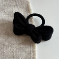 Macro shot of black woolen bow hair tie showing thick soft knitted texture and detail - Black