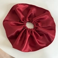 Primer plano de un coletero grande de satén rojo con textura brillante y diseño plisado - Coletero grande / Rojo