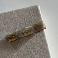Close-up of beige marble acetate hair clip with gold Love metal tag on linen fabric - 1# Gray Texture